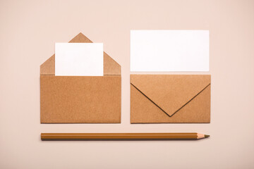 Brown paper envelopes with white cards and brown pencil