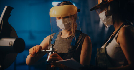 Fototapeta na wymiar Female industry workers checking metal pipe detail