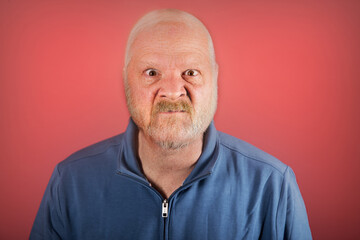 Angry old white man in front of a red background