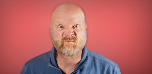 Angry old white man in front of a red background
