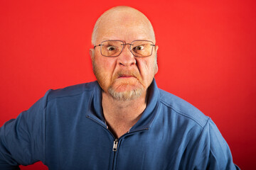 Angry old white man in front of a red background