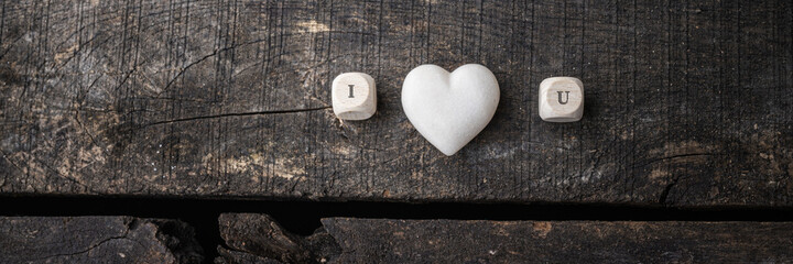 Obraz premium I love you sign spelled on wooden dicer with marble made heart in the middle