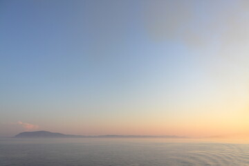 sunset over the sea with land in sight