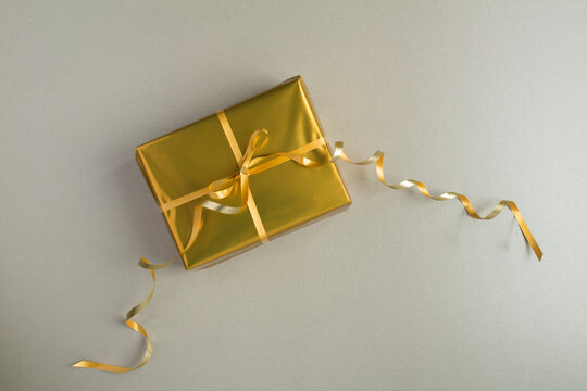 Top View Of Gold Gift Box On The Gray Background