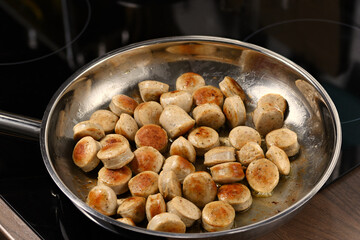 Traditional ​​German sausages in the pan. Fried sausages.
