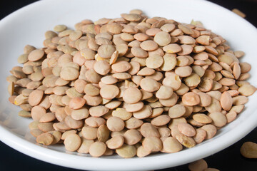 lentils on a white plate, the plate is on a glass table