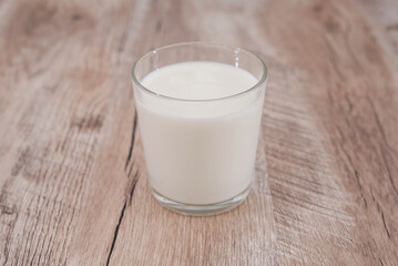 glass of milk on a wooden background.
