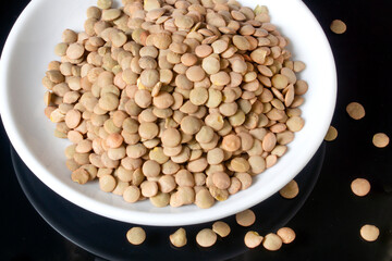 lentils on a white plate, the plate is on a glass table