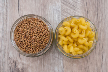 buckwheat and pasta in jars on a wooden background.