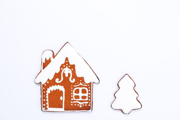 The hand-made eatable gingerbread house and New Year Tree on white background