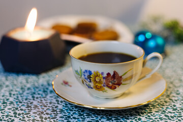 Cup of coffee, candle, cookies and Christmas decorations on a blue background