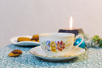 Cup of coffee, candle, cookies and Christmas decorations on a blue background