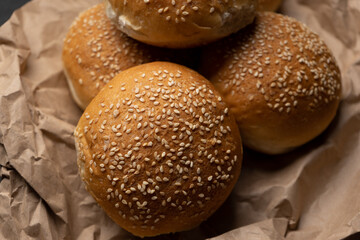 Burger bun bread with sesame seeds on dark background