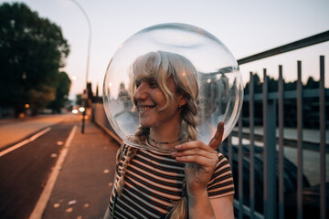 Young woman on street with glass bowl on her head