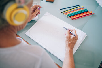 Woman wearing headphones and drawing