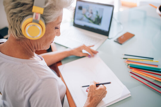 Woman drawing whilst taking online art class