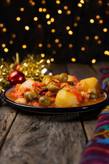 Mexican style cod called a la vizcaina on wooden background