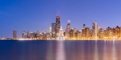 Illuminated view of urban skyline at dusk, Chicago, USA