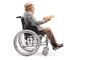 Full length profile shot of an elderly man in a wheelchair holding a throwing plastic disk