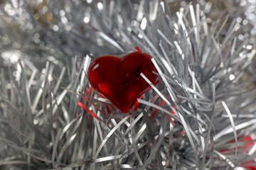 beautiful red heart shape among silver tinsel. Romantic background for Christmas. valentine's day