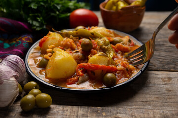 Mexican style cod called a la vizcaina on wooden background