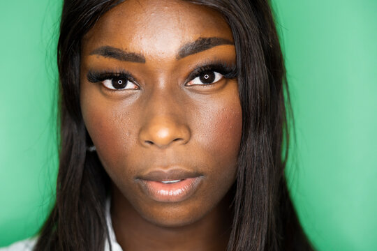 Close-up of woman face against green background
