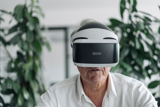 Businessman wearing virtual reality eyeglasses while sitting at office
