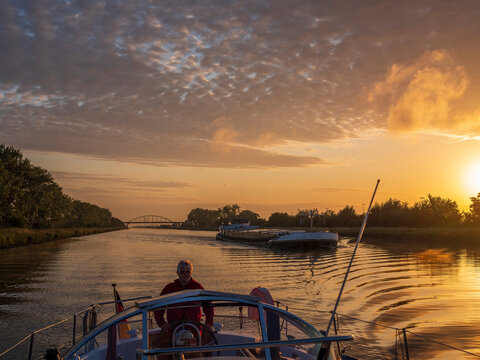 Man sailing boat along Juliana Canal at sunrise