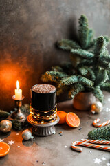 Cocoa with froth and caramel canes. Christmas atmosphere with fir and candles. New Year's treats.