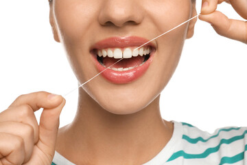 Young woman flossing her teeth on white background, closeup. Cosmetic dentistry - obrazy, fototapety, plakaty
