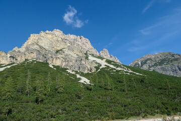 A distant view on a high mountain in Italian Dolomites. It has very steep slopes, full of...