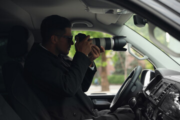 Private detective with camera spying from car