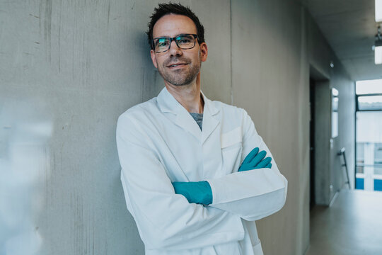 Scientist leaning on wall at clinic corridor