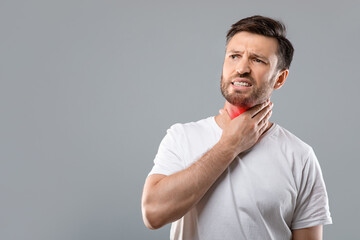 Sick man having sore throat, looking at copy space