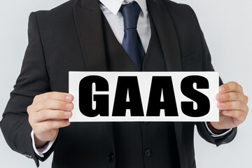 A businessman holds a sign in his hands which says GAAS - Generally accepted audit standards