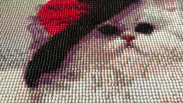Driving the camera through the mosaic -  diamond drawing. A white cat in a hat is laid out of multi-colored acrylic diamonds