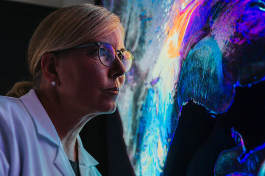 Female scientist studying about human brain with nerve fiber while standing at laboratory