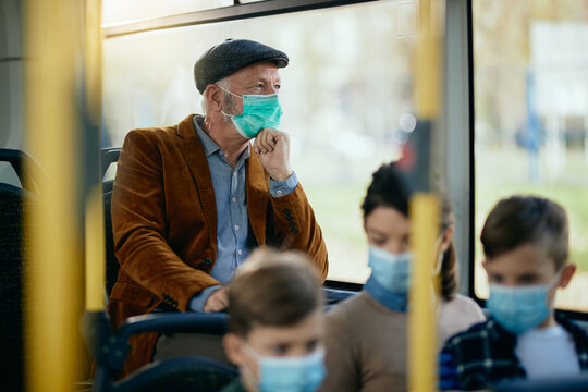 Pensive senior man wearing a face mask while commuting by bus. - Powered by Adobe