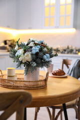 Beautiful winter bouquet on wooden table in kitchen