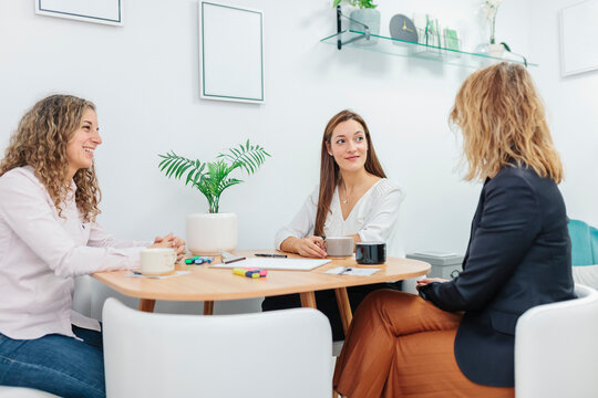 Women having coffee while sitting at office