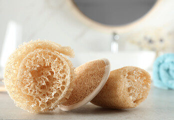 Natural loofah sponges on table in bathroom, closeup