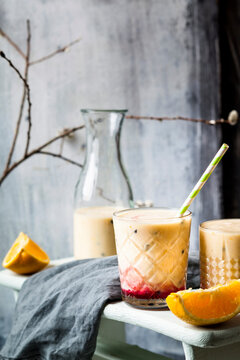 Glasses of fresh fruit smoothie with oranges, bananas, yogurt and grenadine