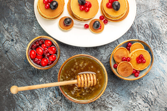 Classic pancakes on wooden cutting board honey in a bowl on gray table stock image