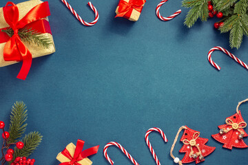 Christmas composition. Wooden red Christmas trees, a fir branch with berries, gifts with red...