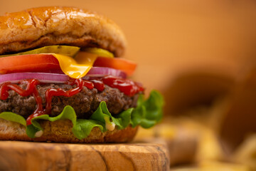 Appetizing burger with bacon wooden board against beige background. Space for text. Photo for menu or cookbook illustration.