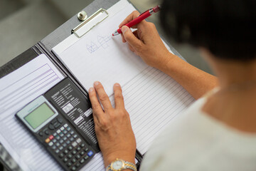 Female architect drawing diagram on clipboard