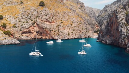 Sa Calobra, Torrent De Pareis beach with turquoise sea water and moored sailing boats in crystal...