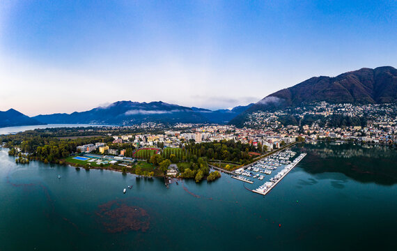 Switzerland, Canton of Ticino, Locarno, Helicopter view of town on shore of Lake Maggiore at dawn