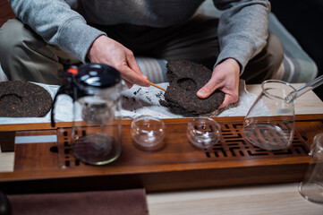 Close up. The hands of the master of the chinese tea ceremony hold a bamboo needle for picking tea