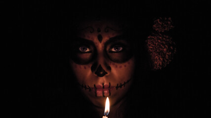 Catrina in the dark with a candle